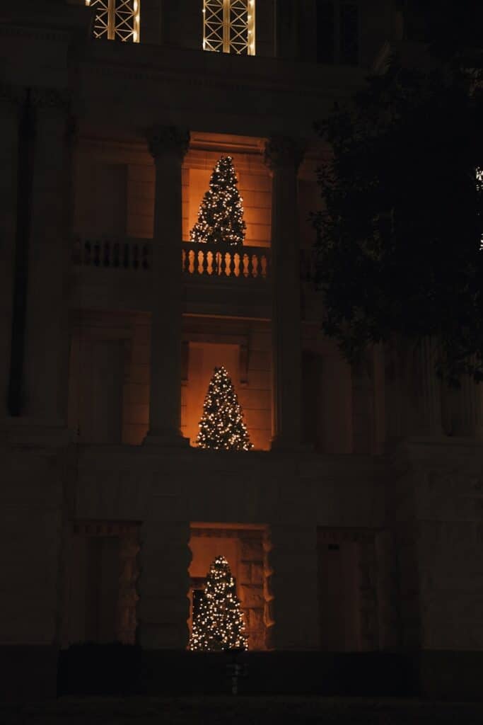 a lit up christmas tree in front of a building
