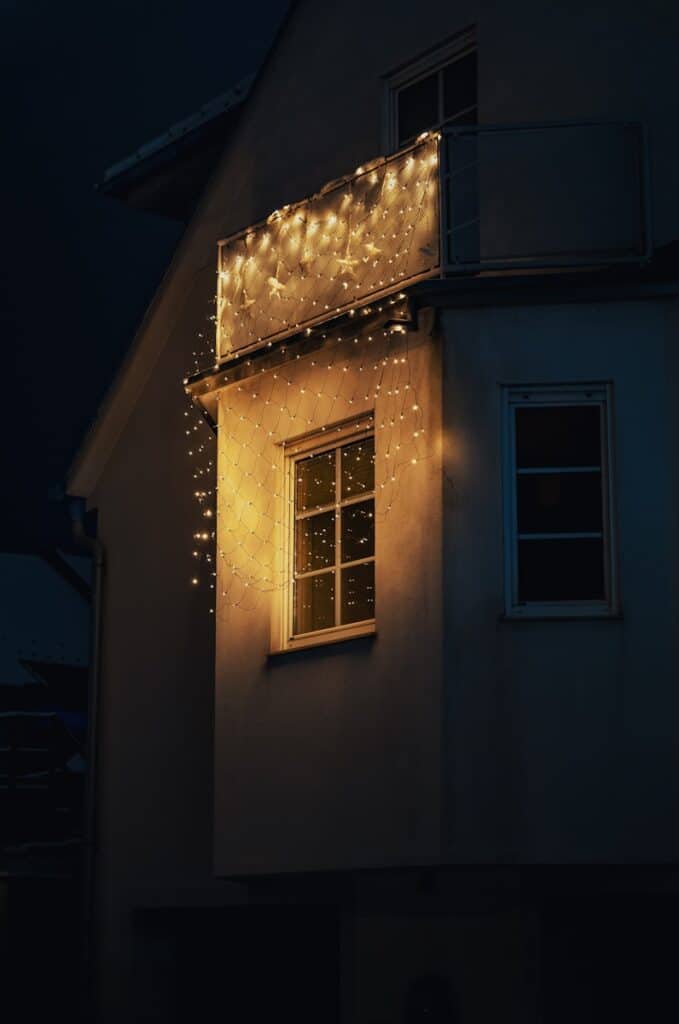 A house illuminated by warm string lights at night.