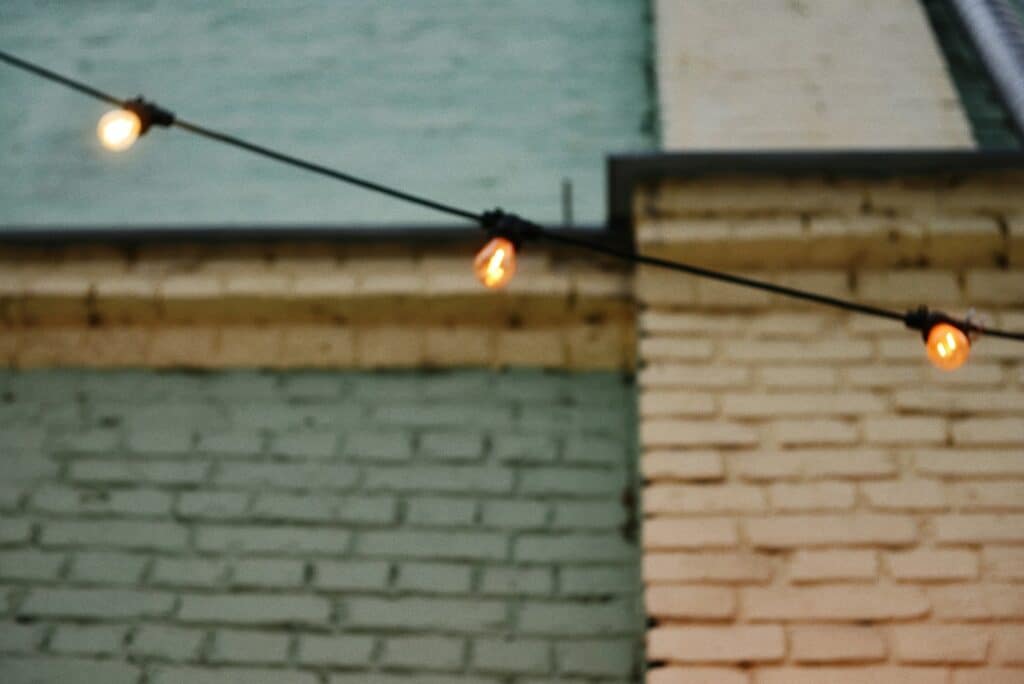 String lights hang against brick walls.
