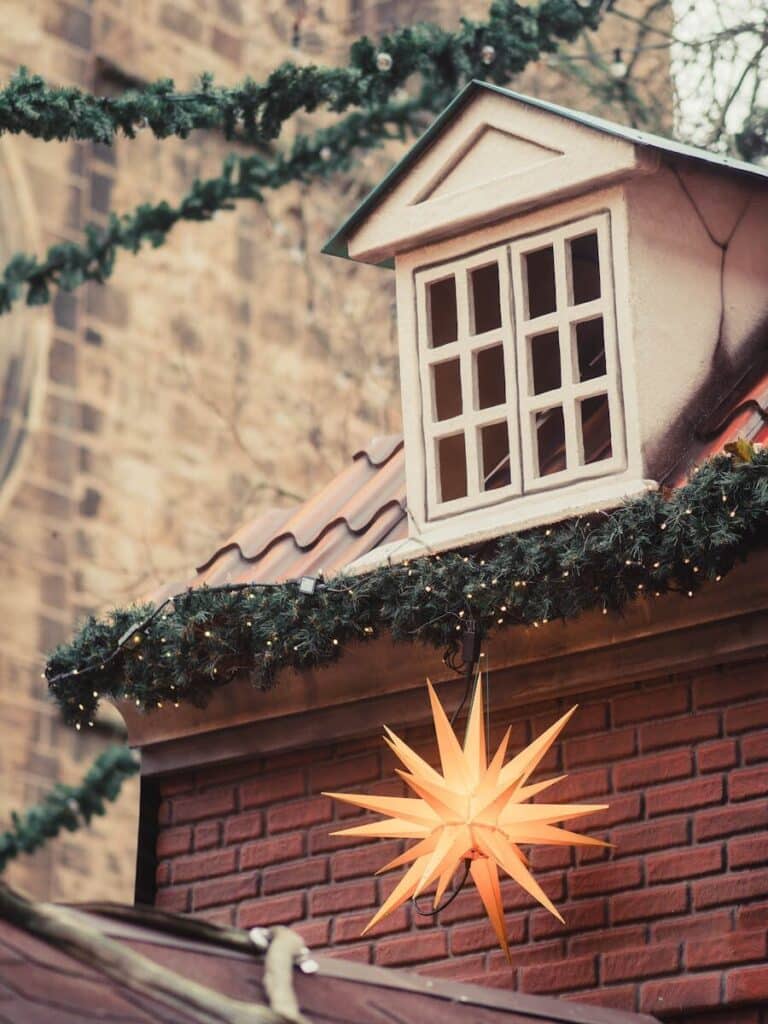 Decorative Christmas market stall with festive star light and spruce garland, creating a warm holiday ambiance.