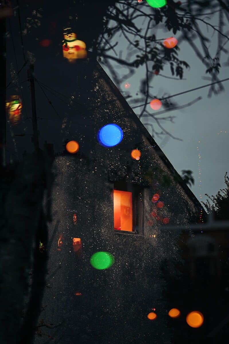Colorful bokeh lights reflect on a house at night.