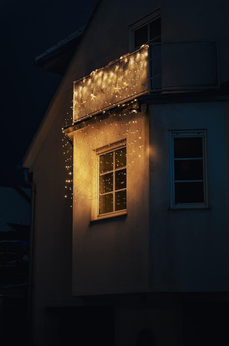 A house illuminated by warm string lights at night.