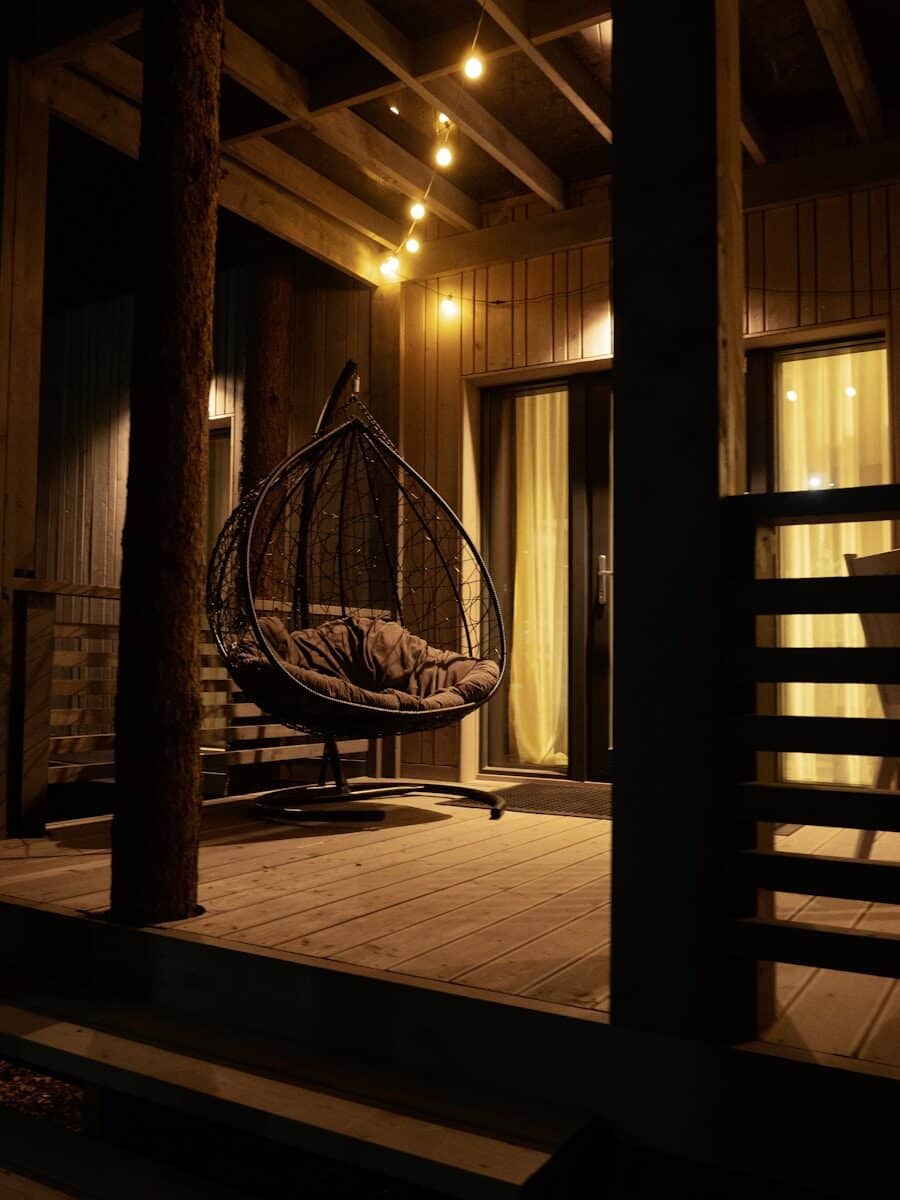 a hanging chair on a porch at night