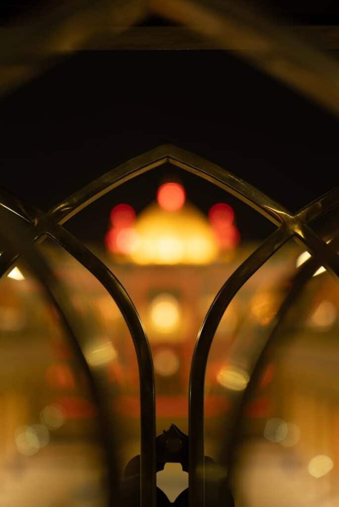 Blurred lights of a building seen through a metal gate.