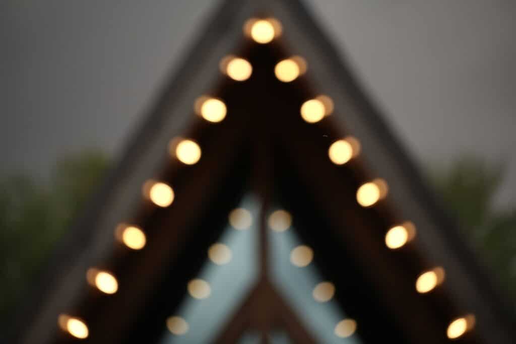 Blurred image of a rooftop with illuminated lights creating an abstract visual effect.