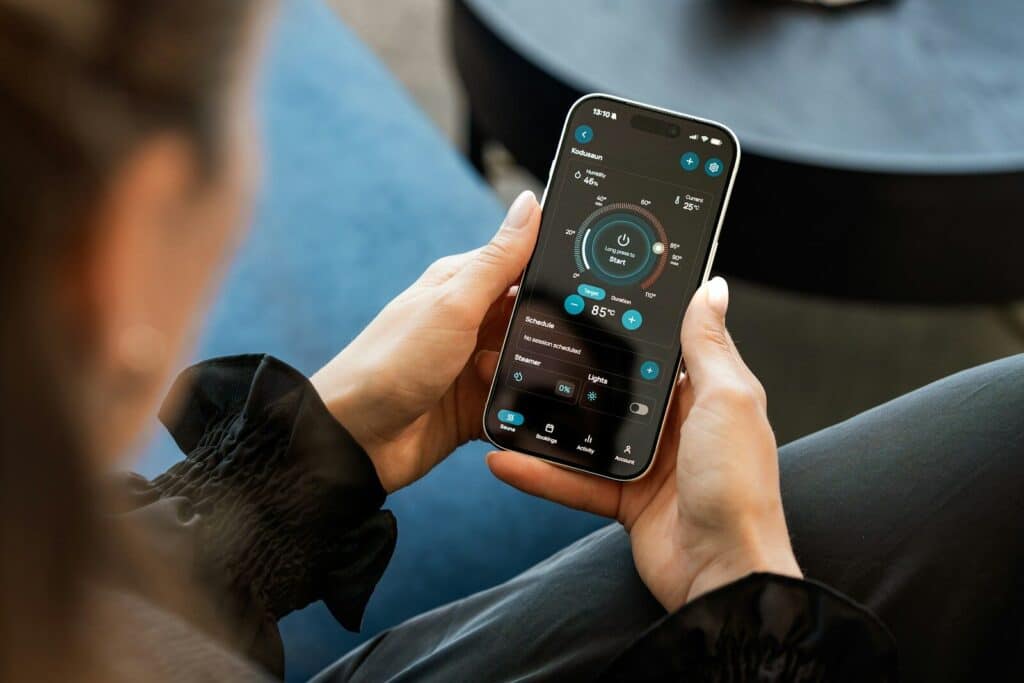 Person holding smartphone, interacting with an app showing controls.