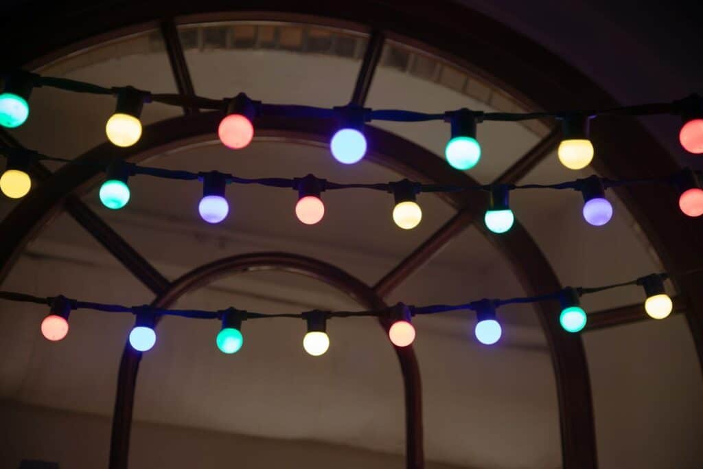 Colorful string lights illuminate a dark room
